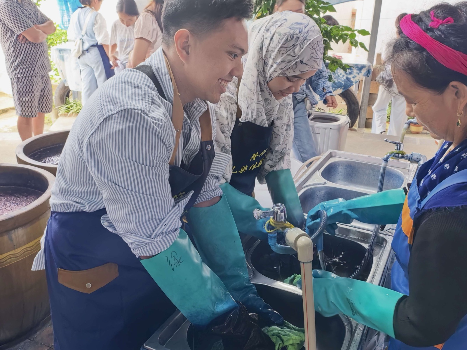 Visitors wearing aprons taking part in a Bai tie-dye workshop