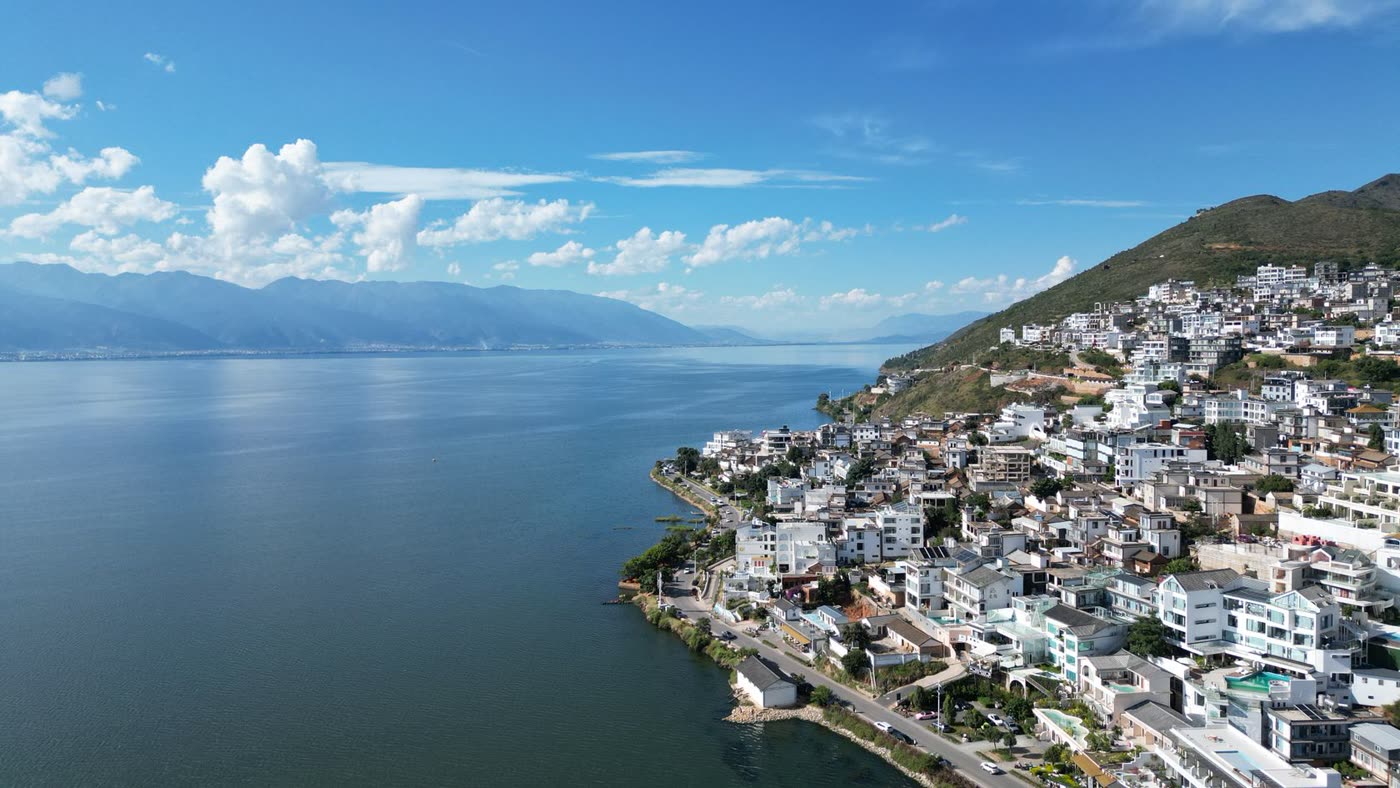 Aerial view across lakeside homes and Erhai Lake with mountains in Dali